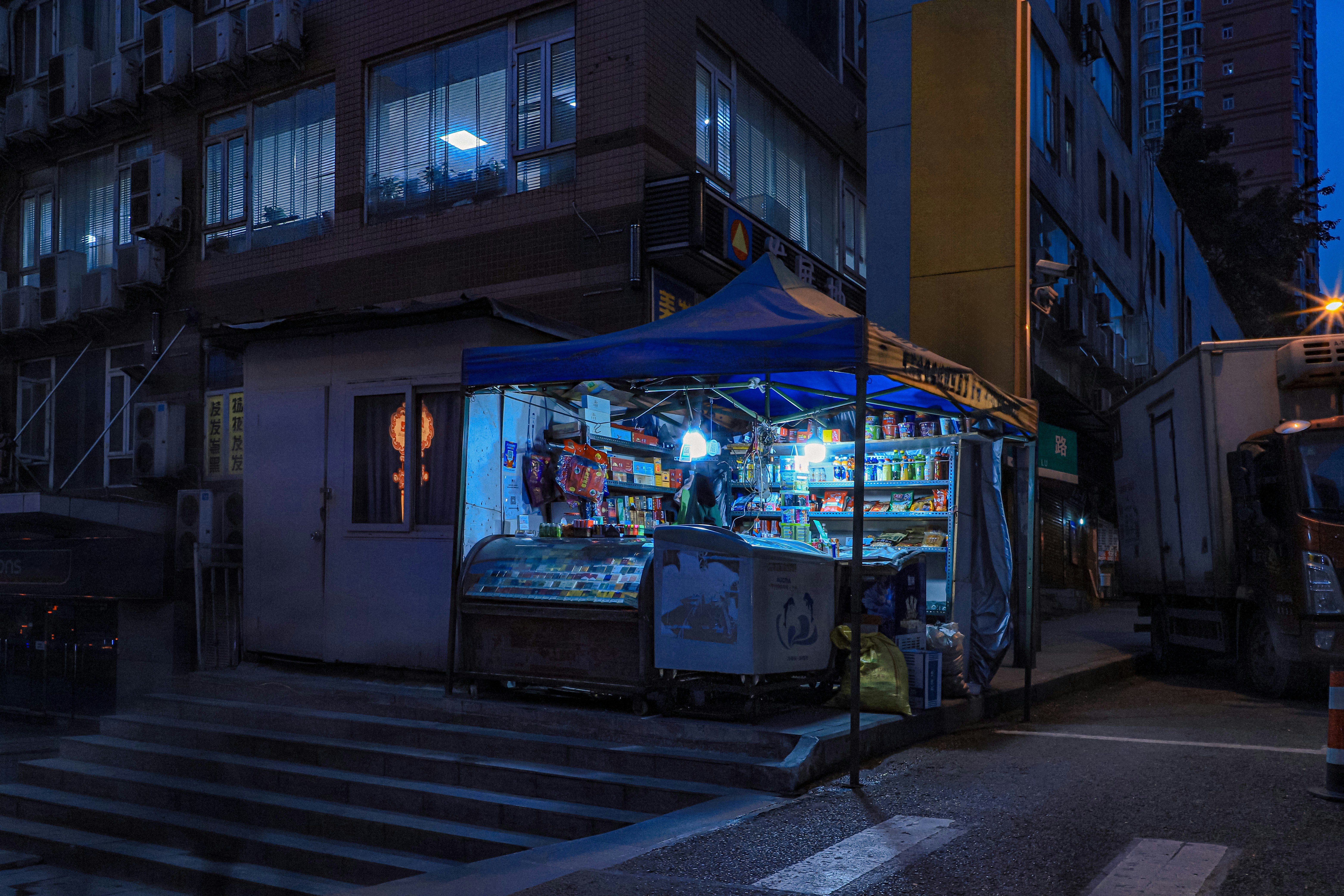 A city street at night with a street vendor