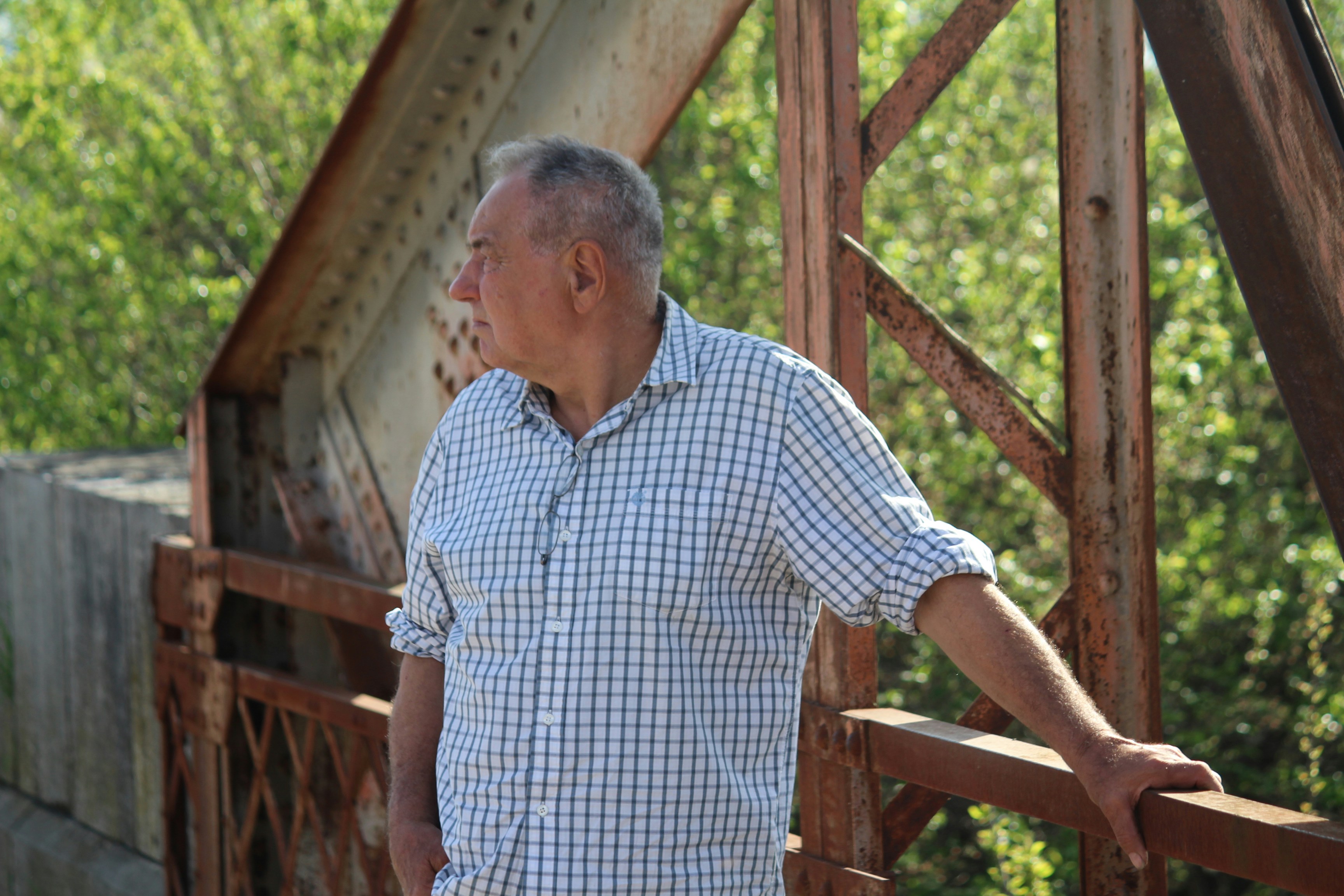 Un homme debout sur un pont en bois à côté d’une forêt