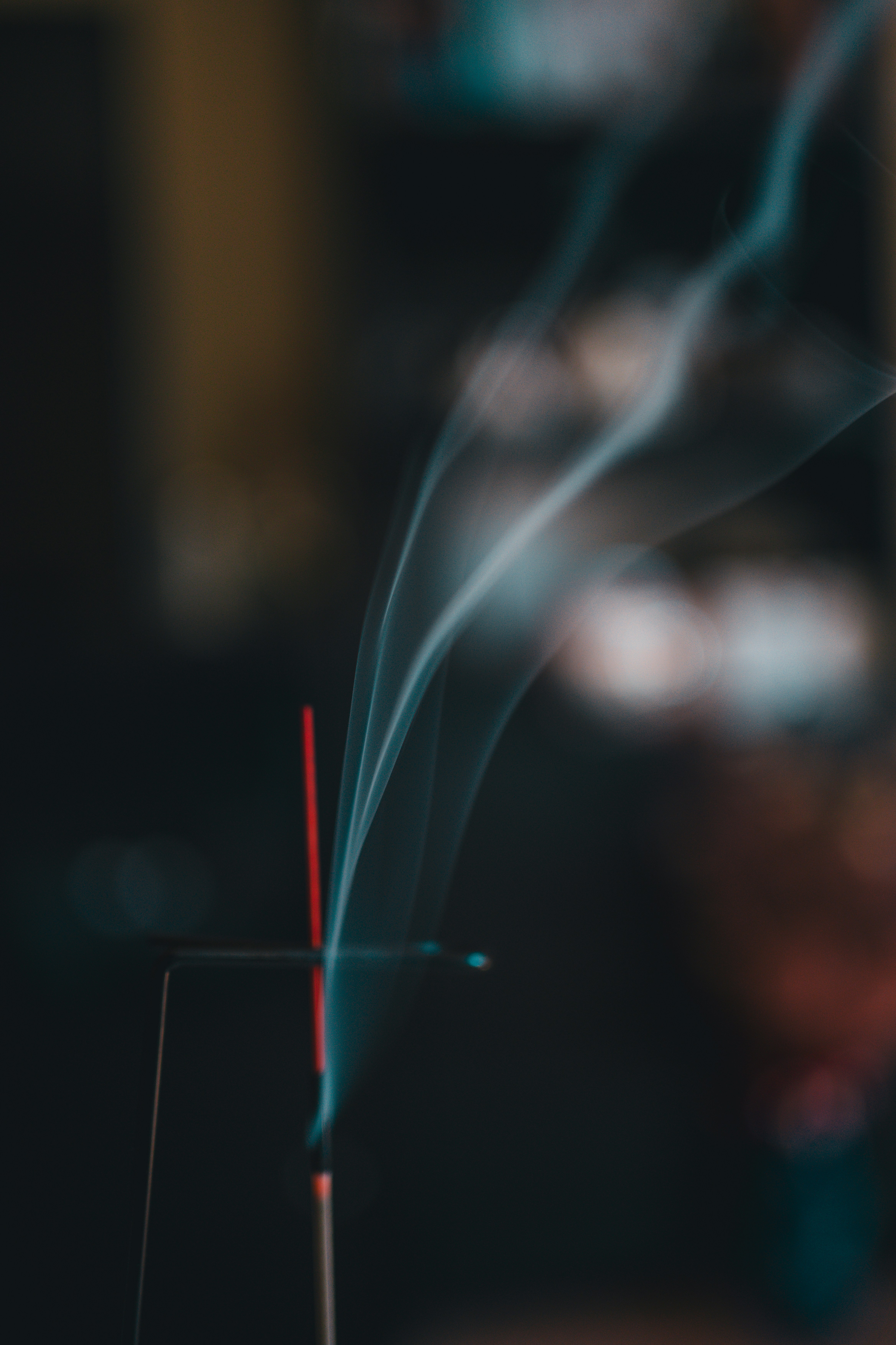 El humo del incienso se eleva suavemente, creando una atmósfera de calma y serenidad. Sus volutas etéreas flotan lentamente en el aire, llenando el espacio con un aroma sutil que invita a la relajación y la introspección. La imagen captura el momento en que el incienso se convierte en un vehículo para la meditación, la tranquilidad y el equilibrio, transformando el entorno en un refugio de paz. Cada hilo de humo refleja la quietud y la armonía que se buscan en un instante de desconexión y renovación espiritual.