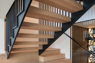 A wooden staircase with black railings in a house