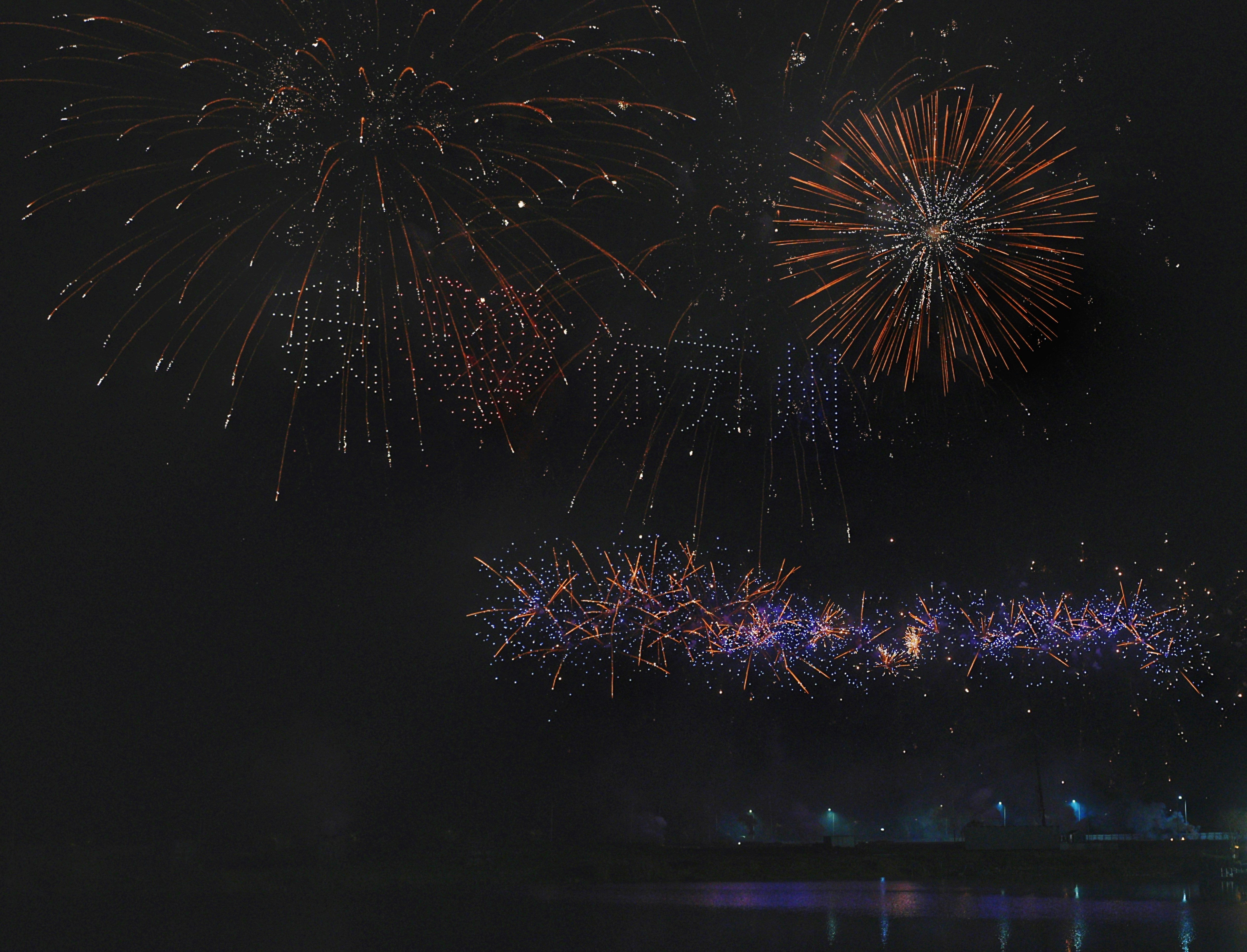 Ein Feuerwerk wird am Himmel über einem Gewässer gezündet