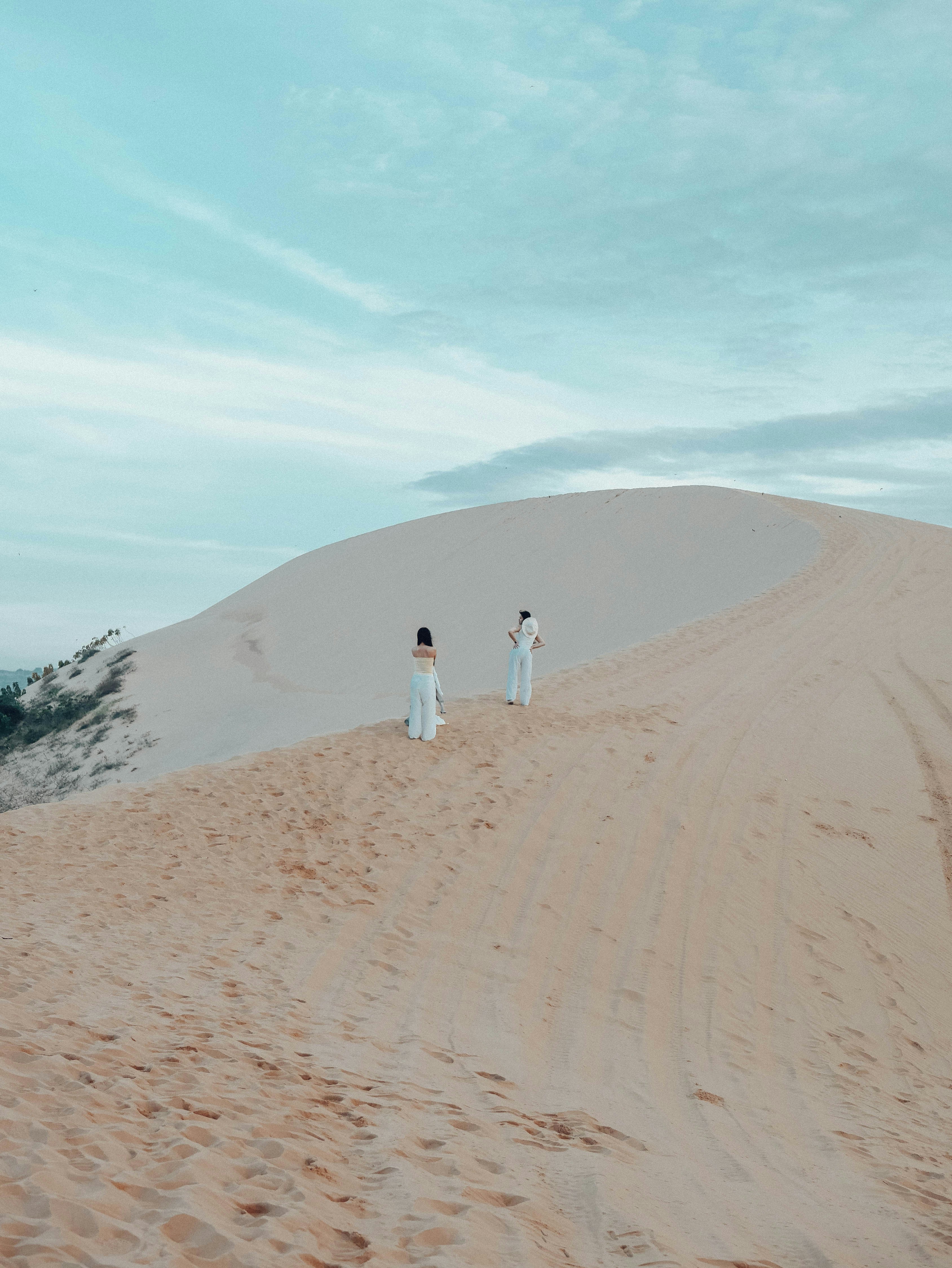 Two people standing on top of a sand dune photo – Free Vietnam Image on ...