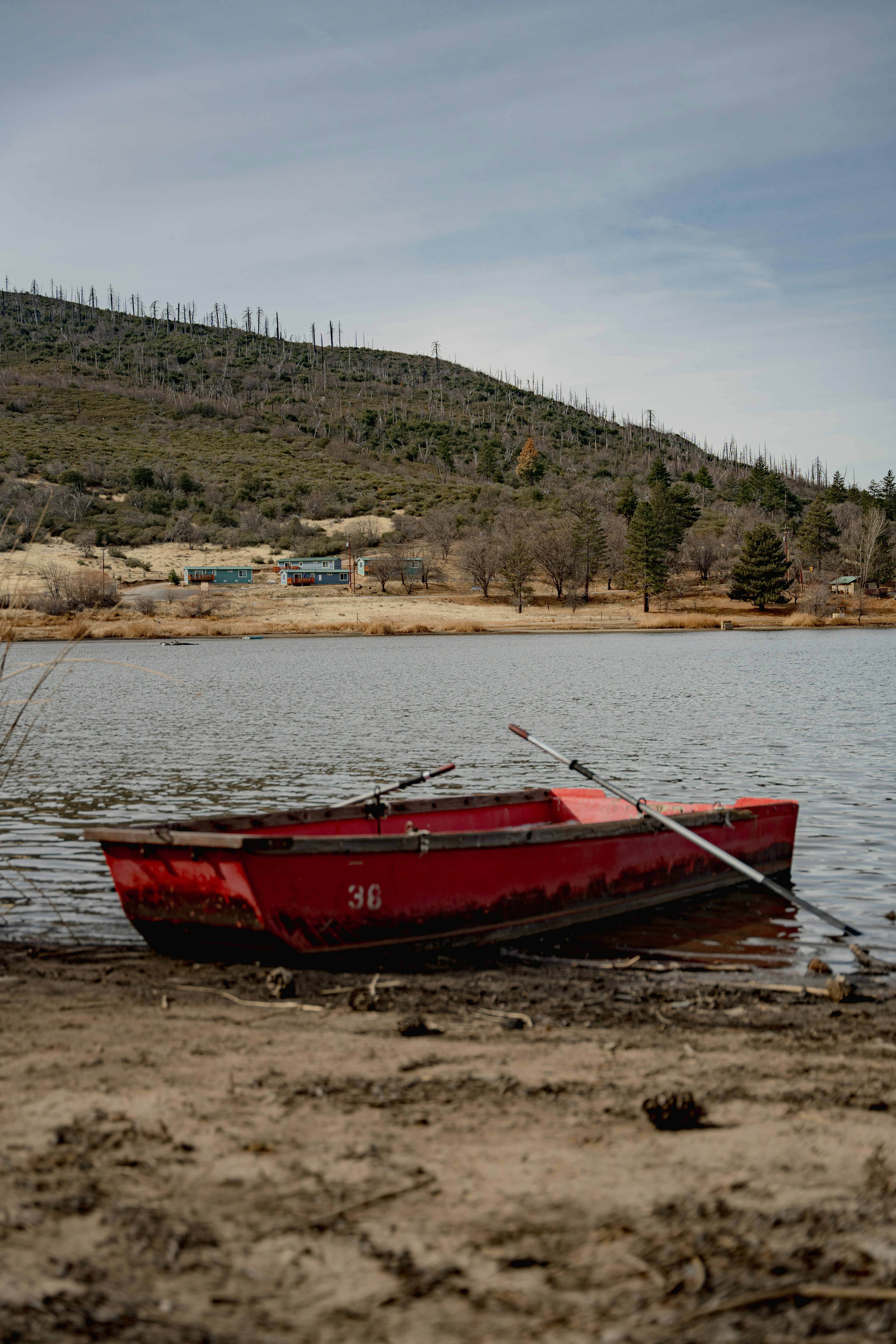 A red boat sitting on top of a sandy beach