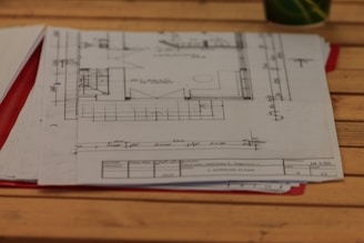 A wooden table topped with lots of papers