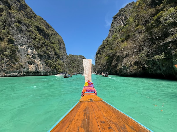 A boat traveling down a river surrounded by mountains