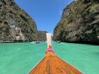 A boat traveling down a river surrounded by mountains
