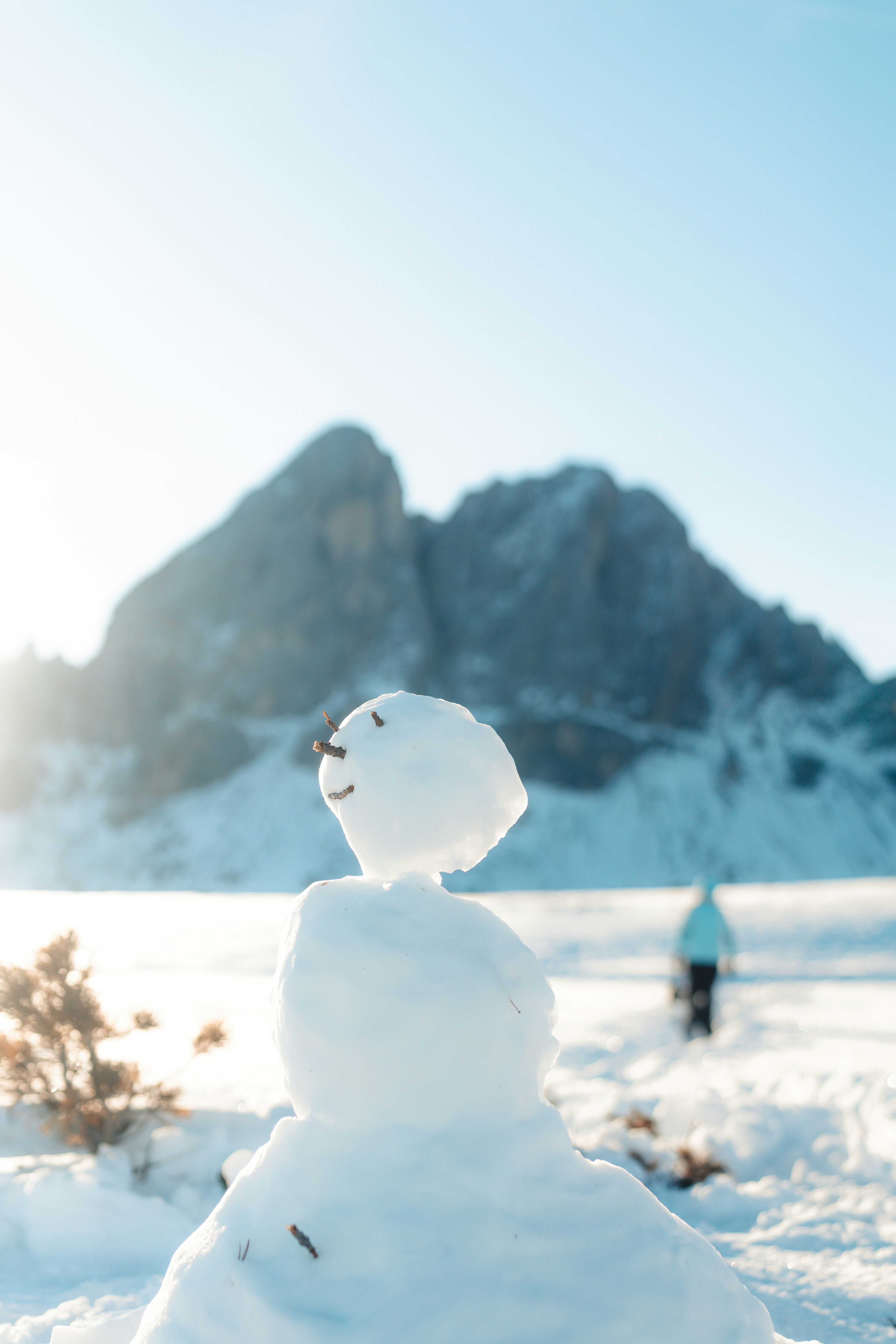 A snowman sitting in the middle of a snowy field