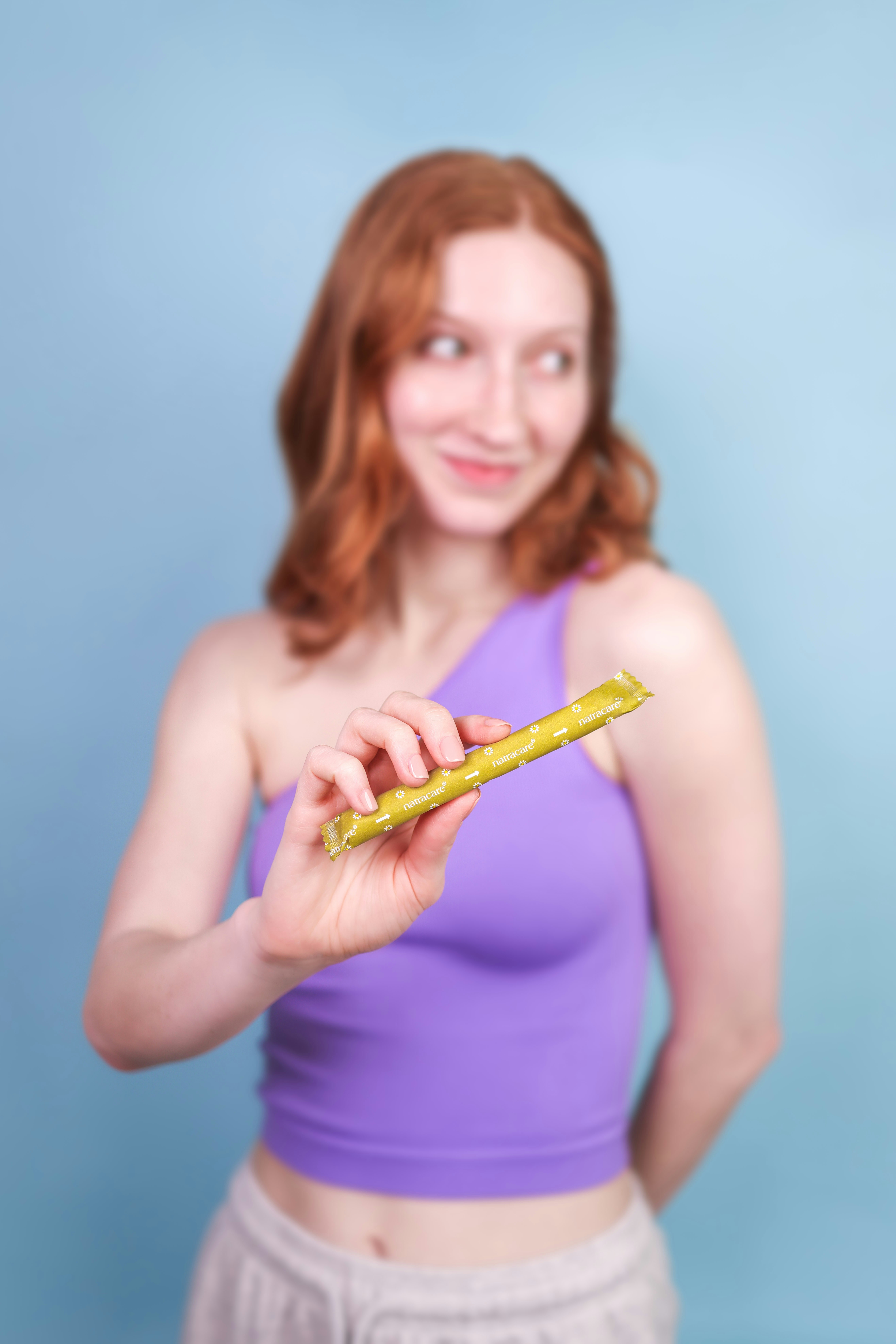 A woman in a purple top holding a piece of food