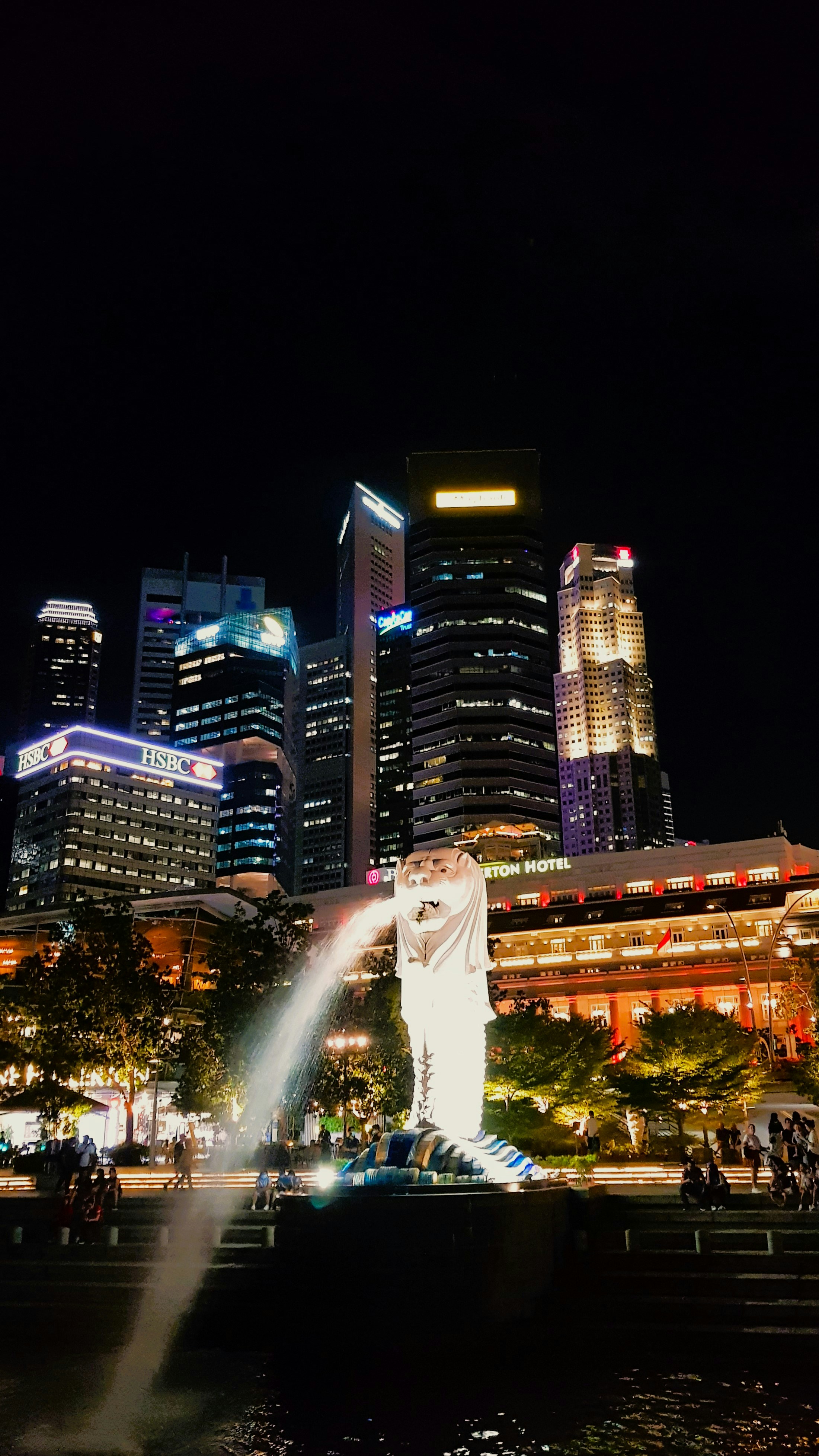 A city at night with a fountain in the foreground