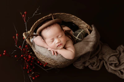 A newborn baby is sleeping in a basket