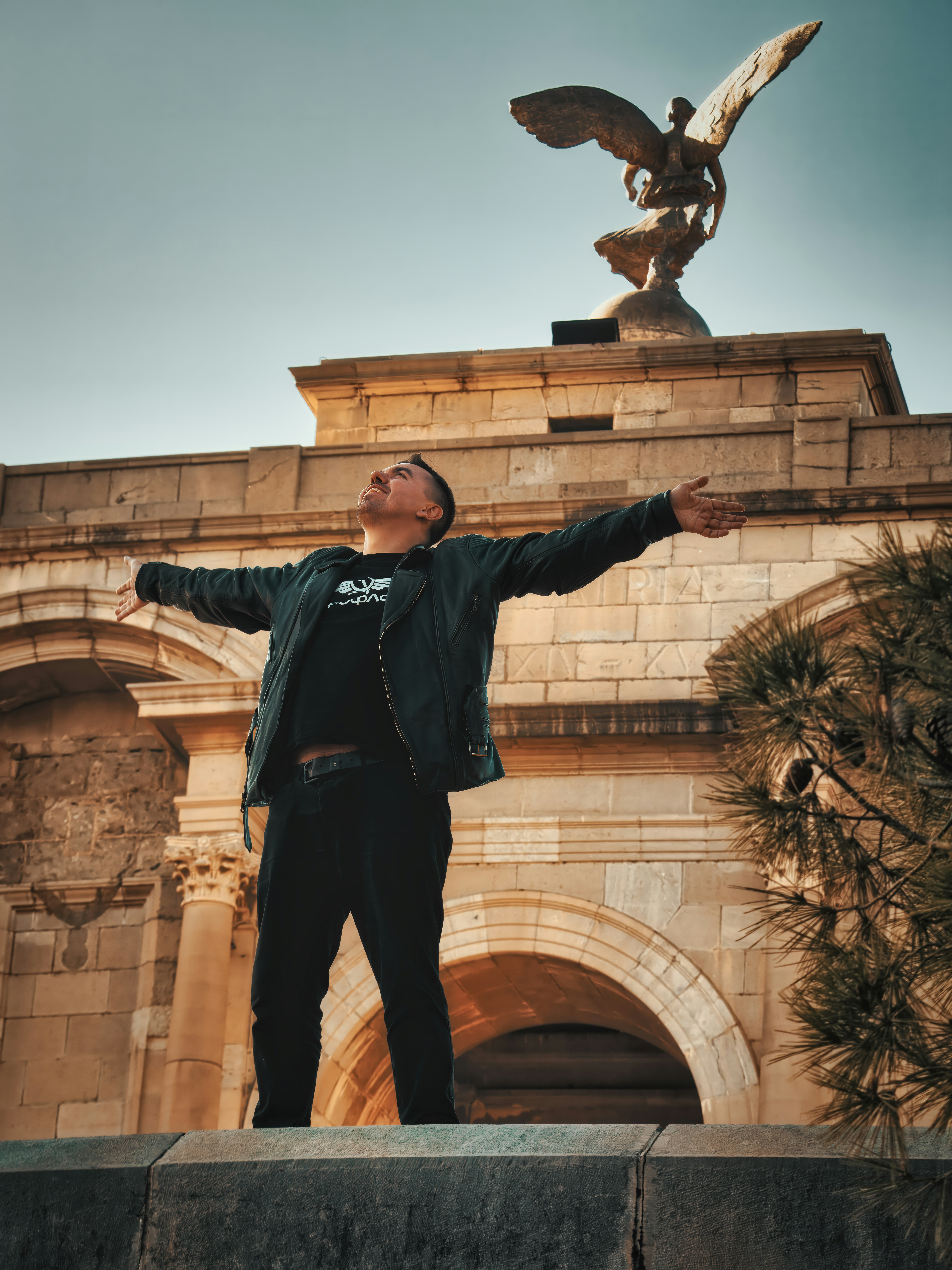 A man standing in front of a statue of an eagle