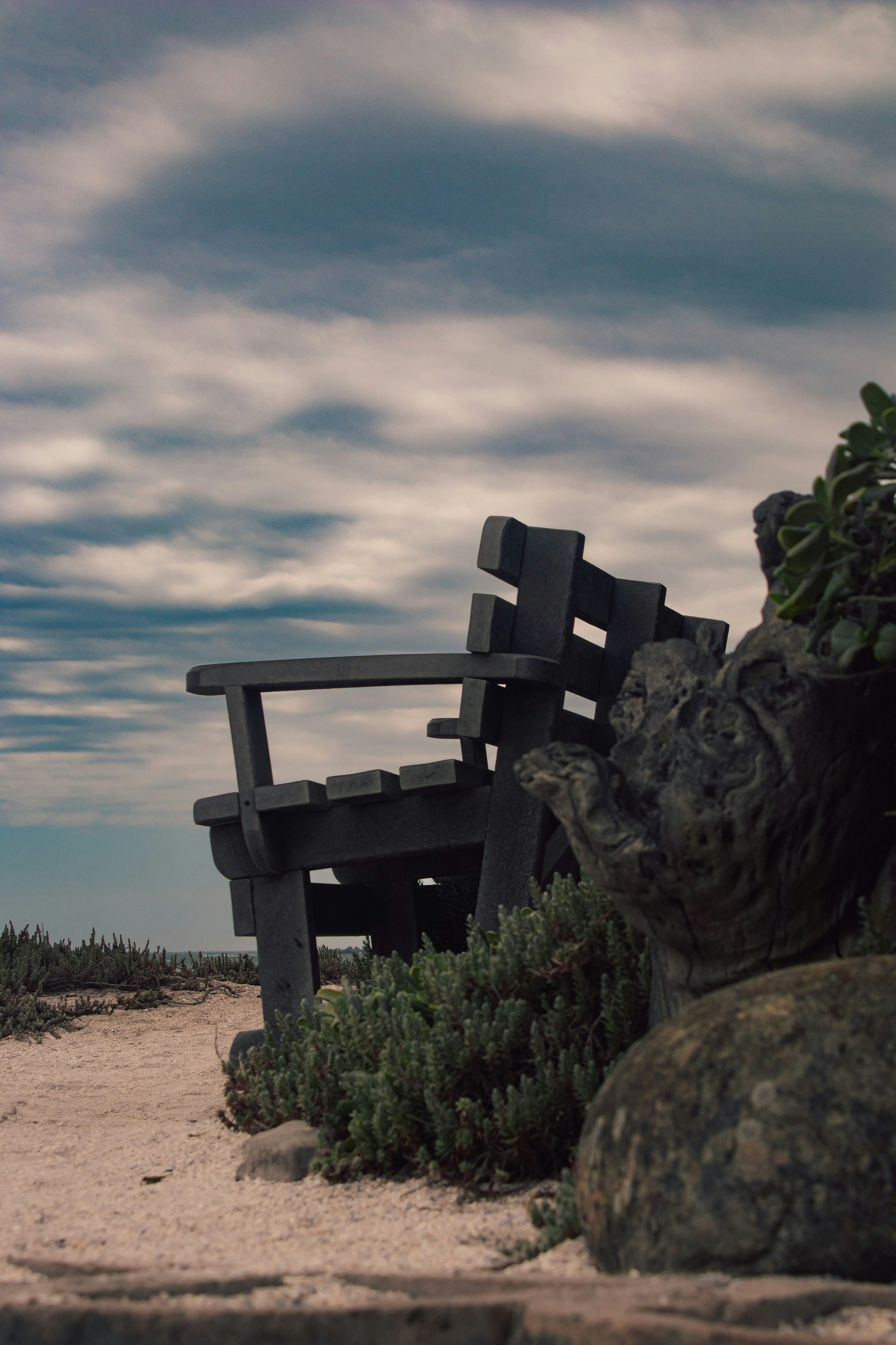 A wooden bench sitting on top of a sandy beach