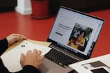 A person sitting at a table with a laptop