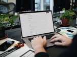A person typing on a laptop on a desk