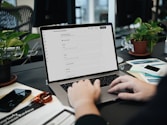 A person typing on a laptop on a desk