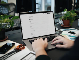 A person typing on a laptop on a desk