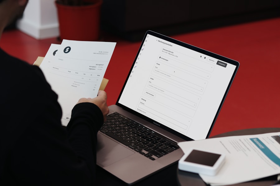 A person at a desk reviews documents next to a laptop while preparing to file a flight compensation claim