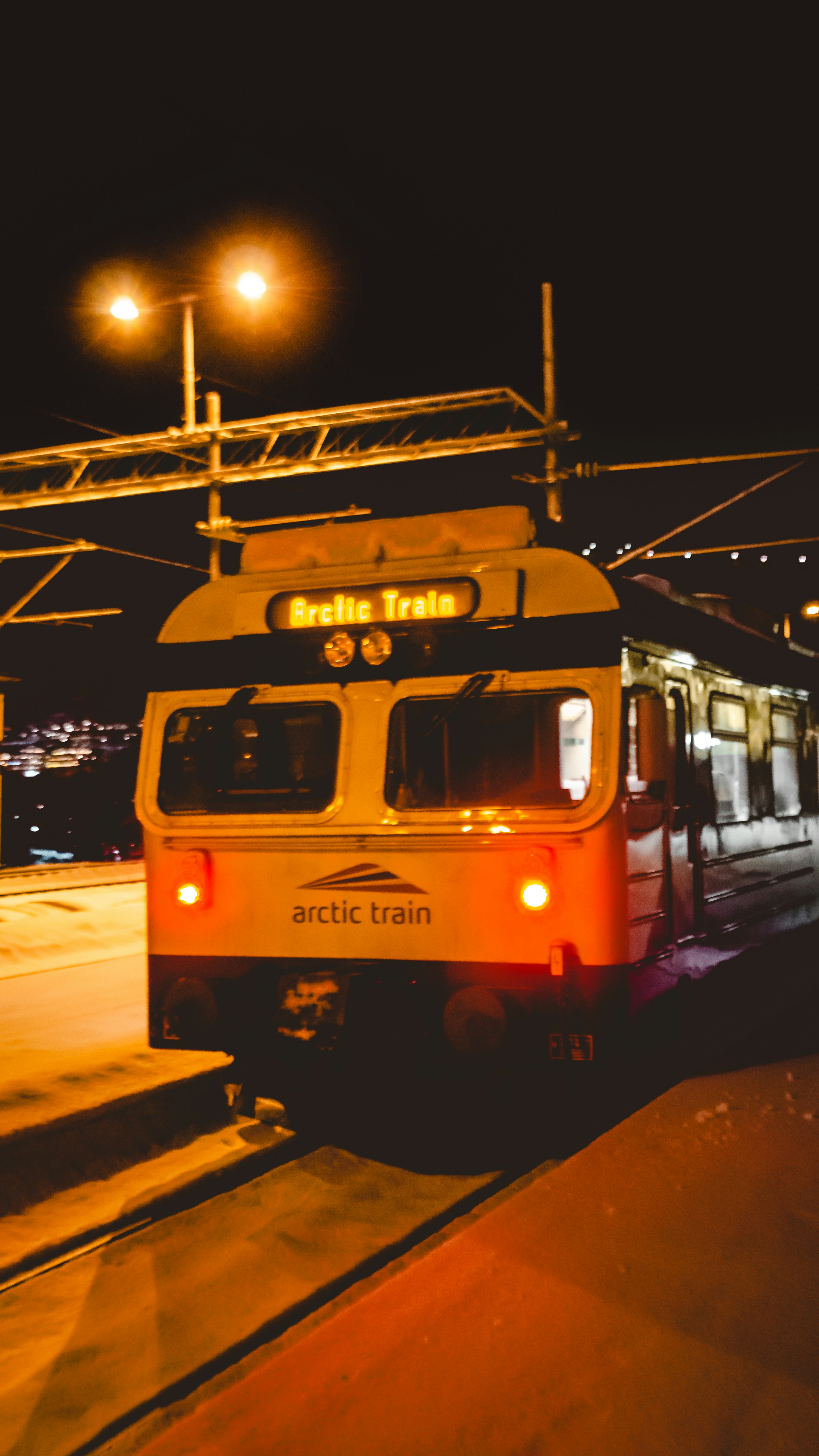 A red and white train traveling down train tracks