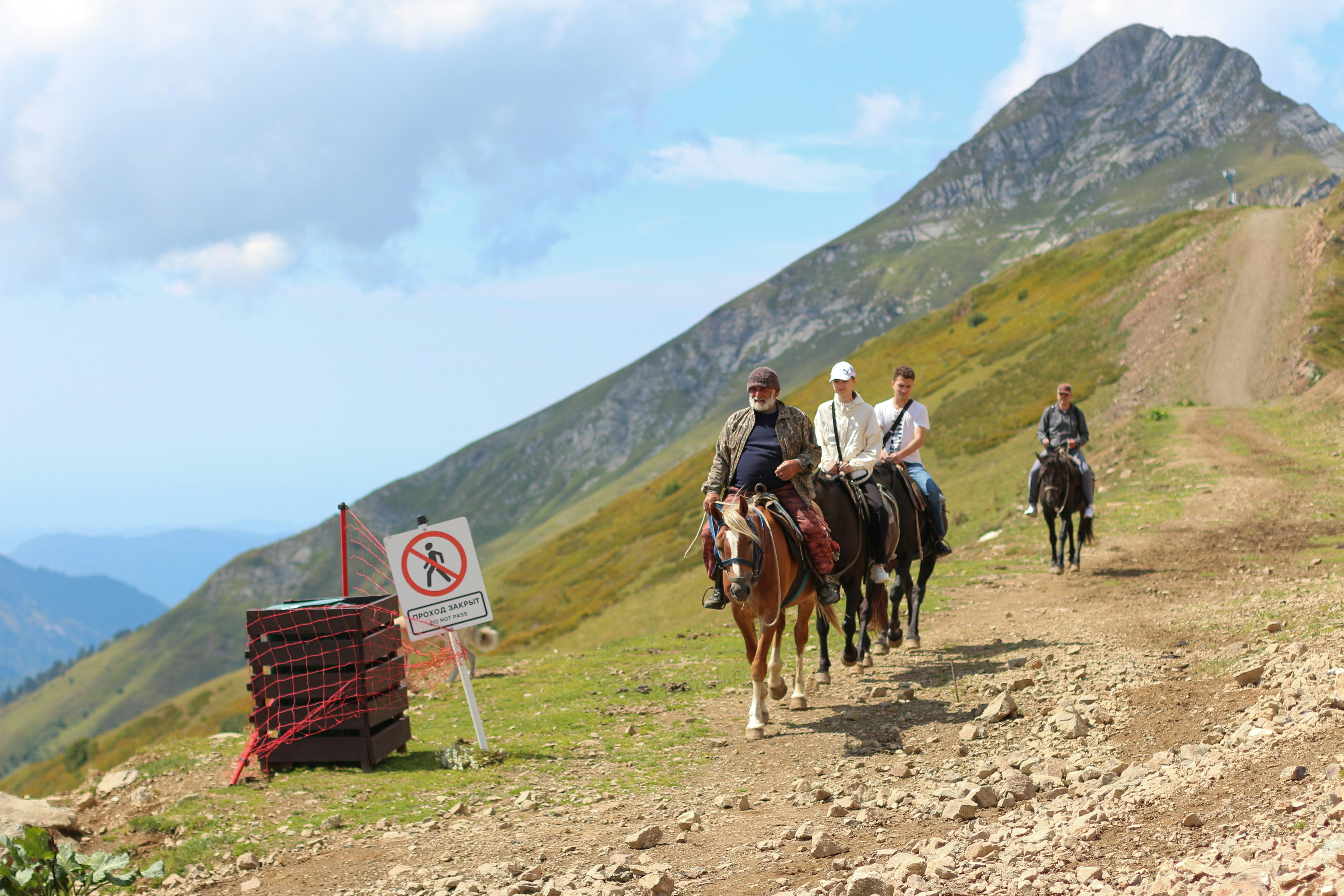 Un groupe de personnes à cheval sur un chemin de terre