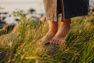 A person standing on a hill with their feet in the grass