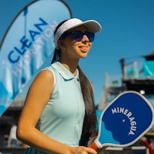 A woman is holding a blue and white paddle