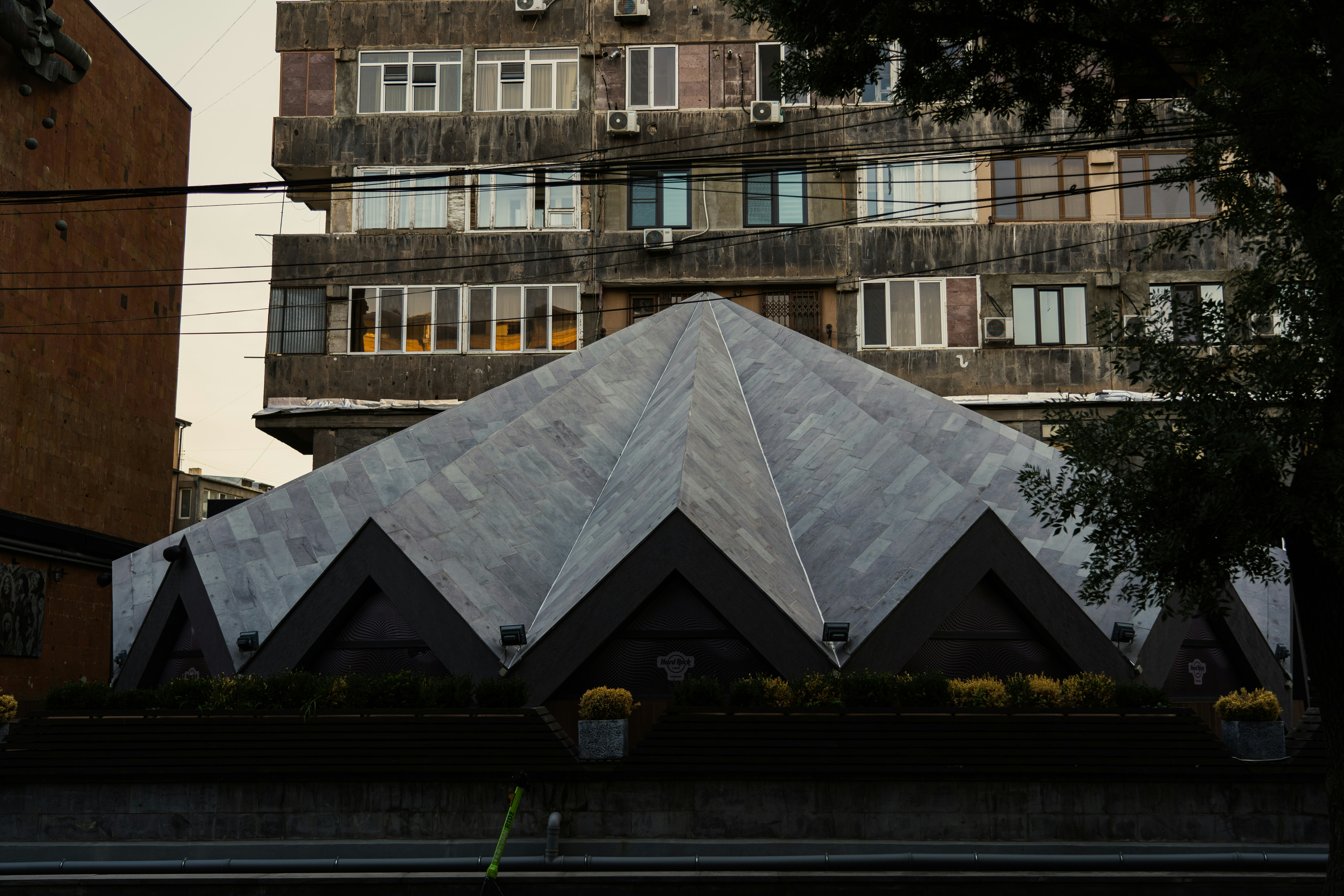 A tall building with many windows next to a tree photo – Free Yerevan ...