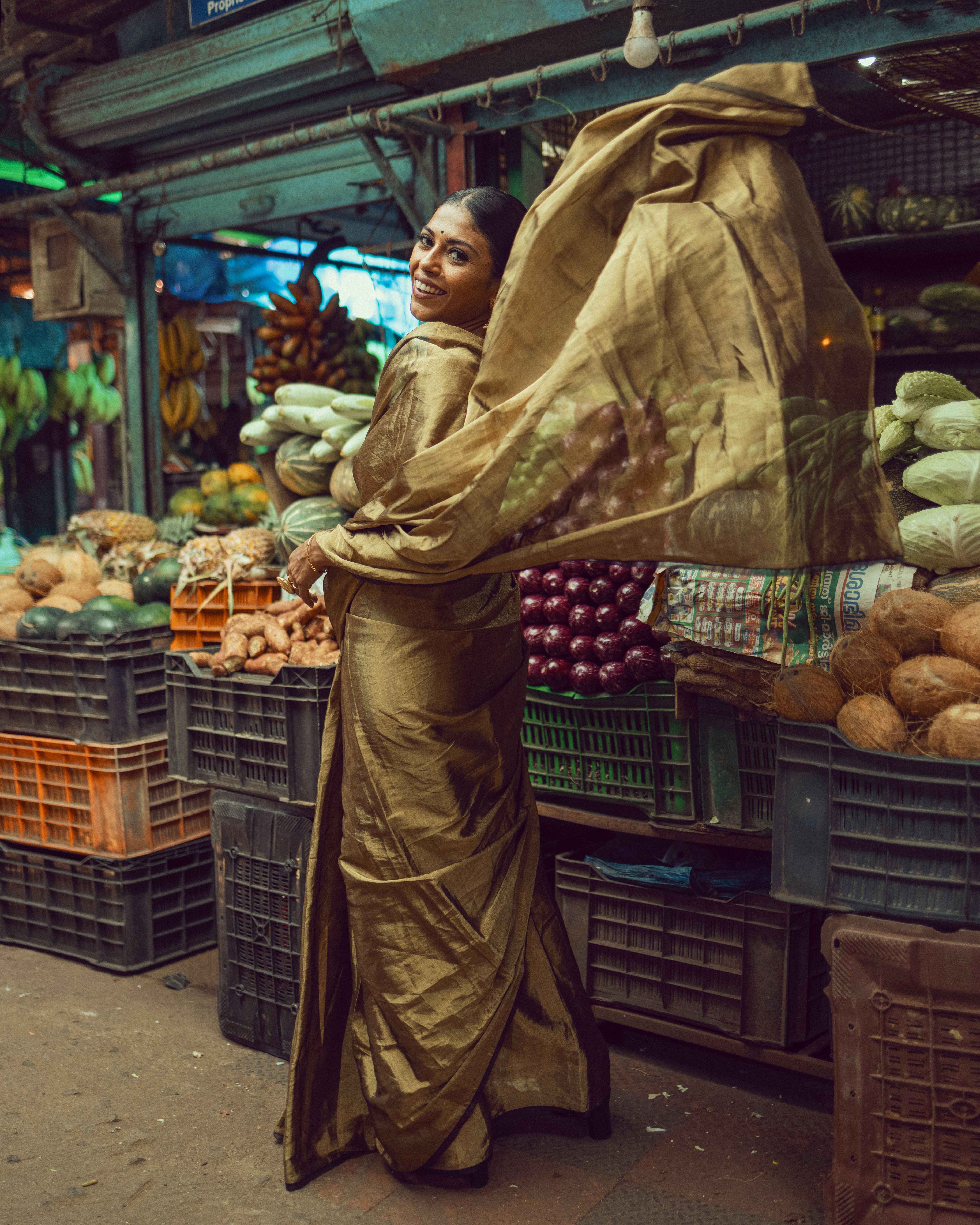 A woman standing in front of a fruit stand