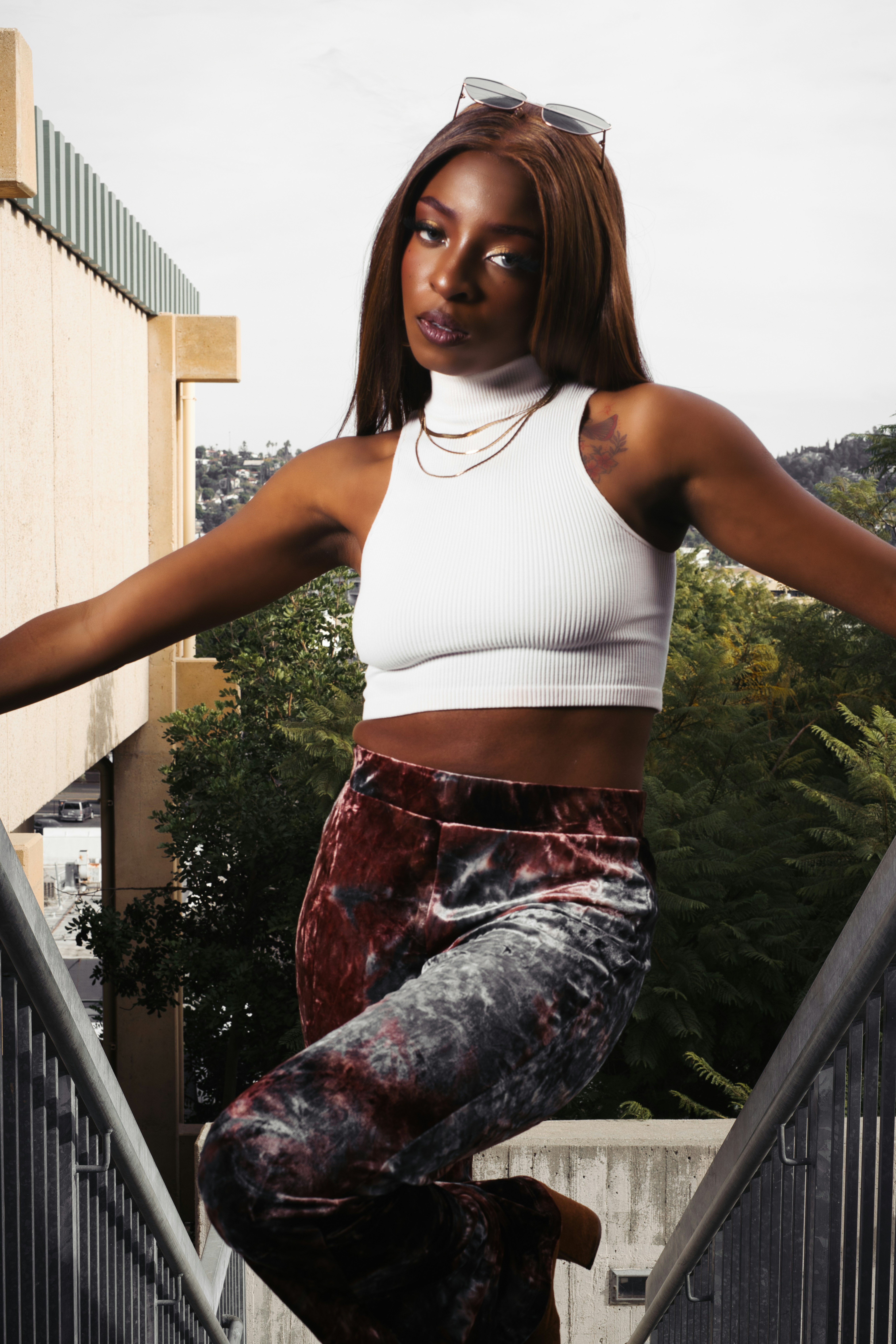 A woman in a white top is standing on some stairs