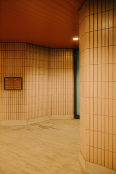 An empty room with tiled walls and wooden floors