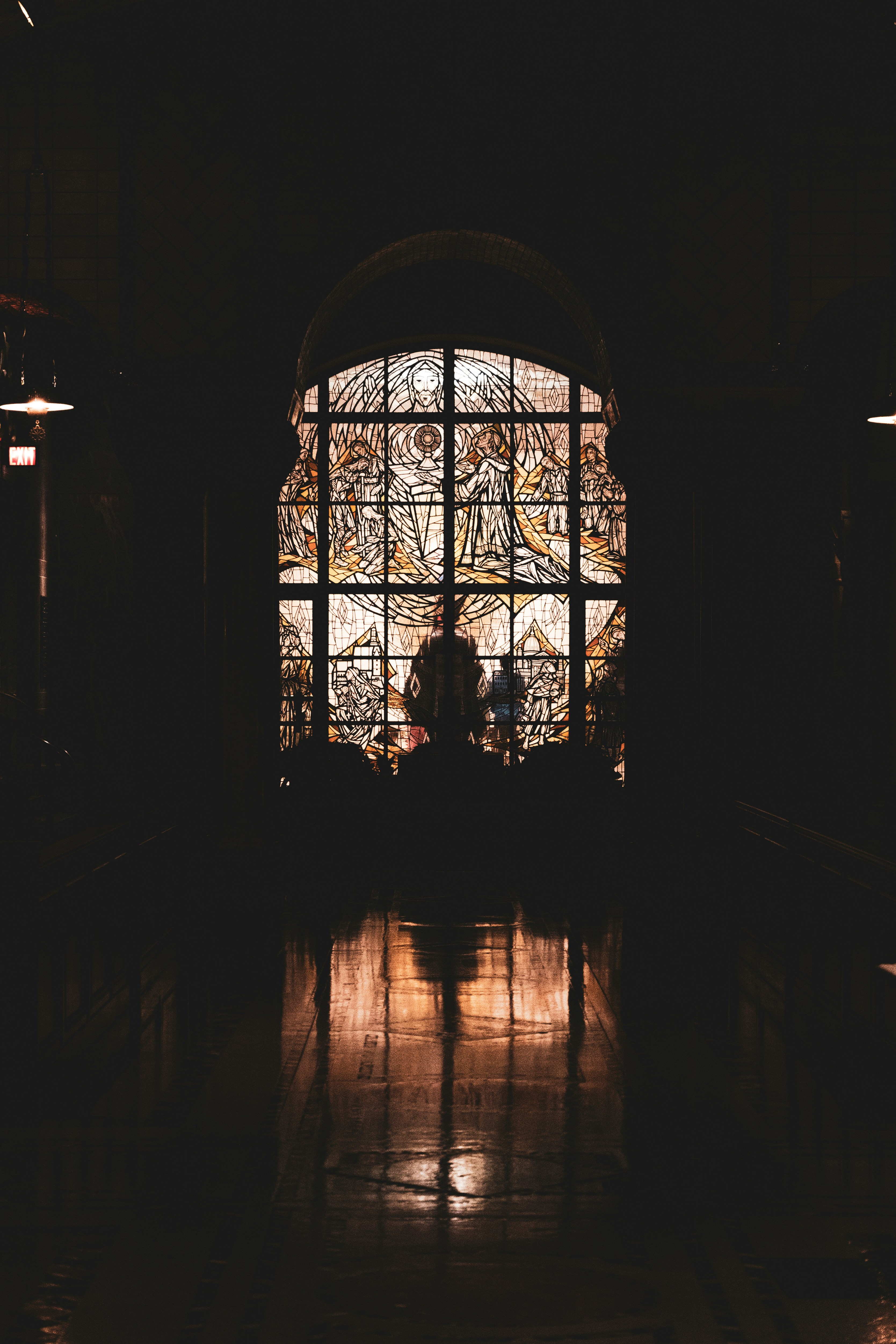 Une pièce sombre avec un grand vitrail