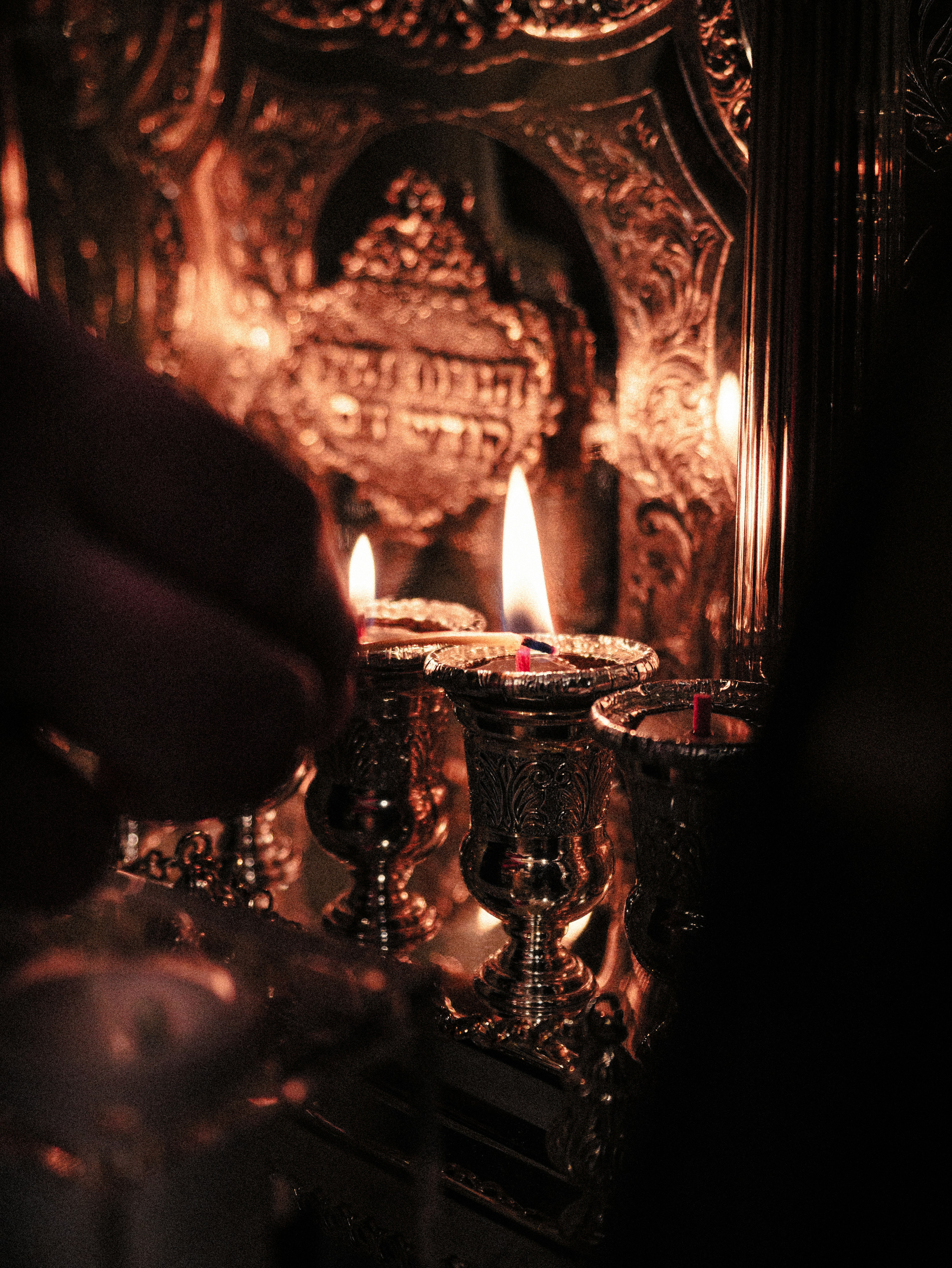 Una persona che tiene una candela accesa davanti a uno specchio