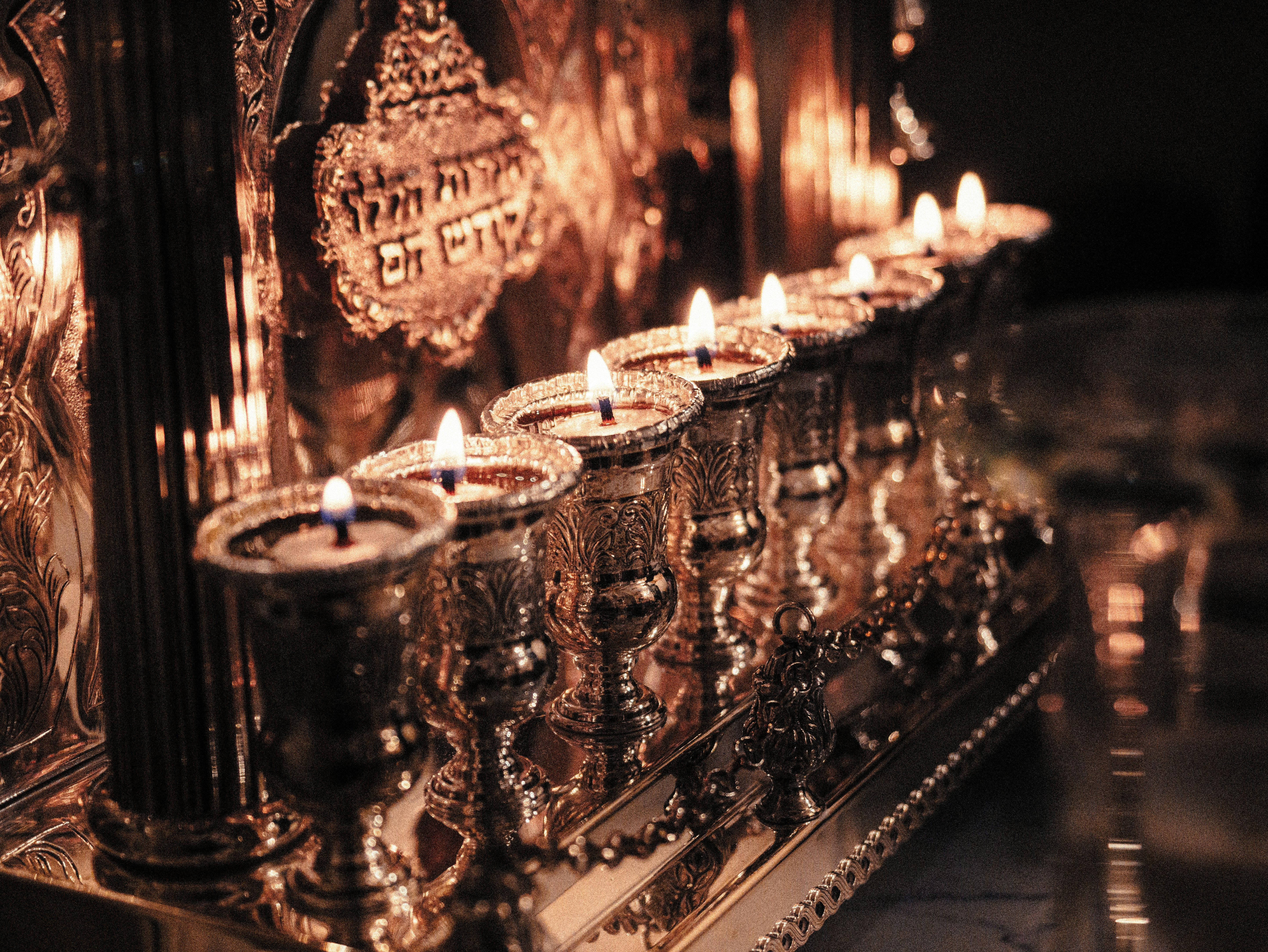A row of lit candles sitting on top of a table