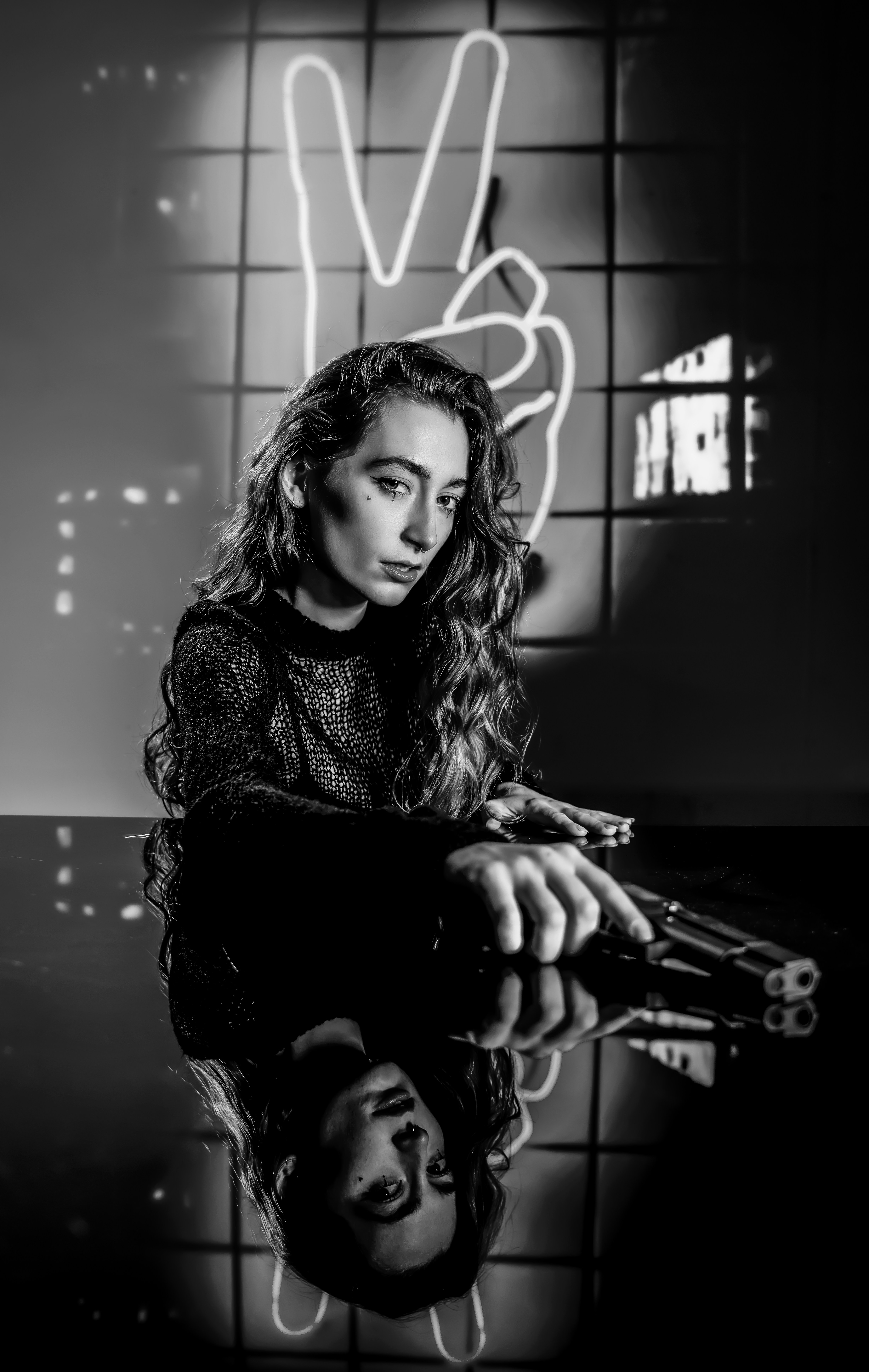 A black and white photo of a woman holding a gun