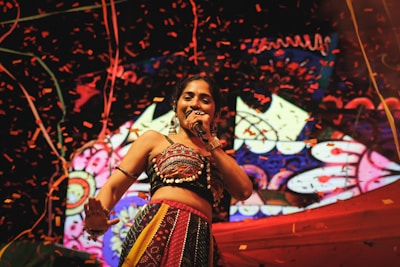 A woman in a belly dance outfit singing into a microphone