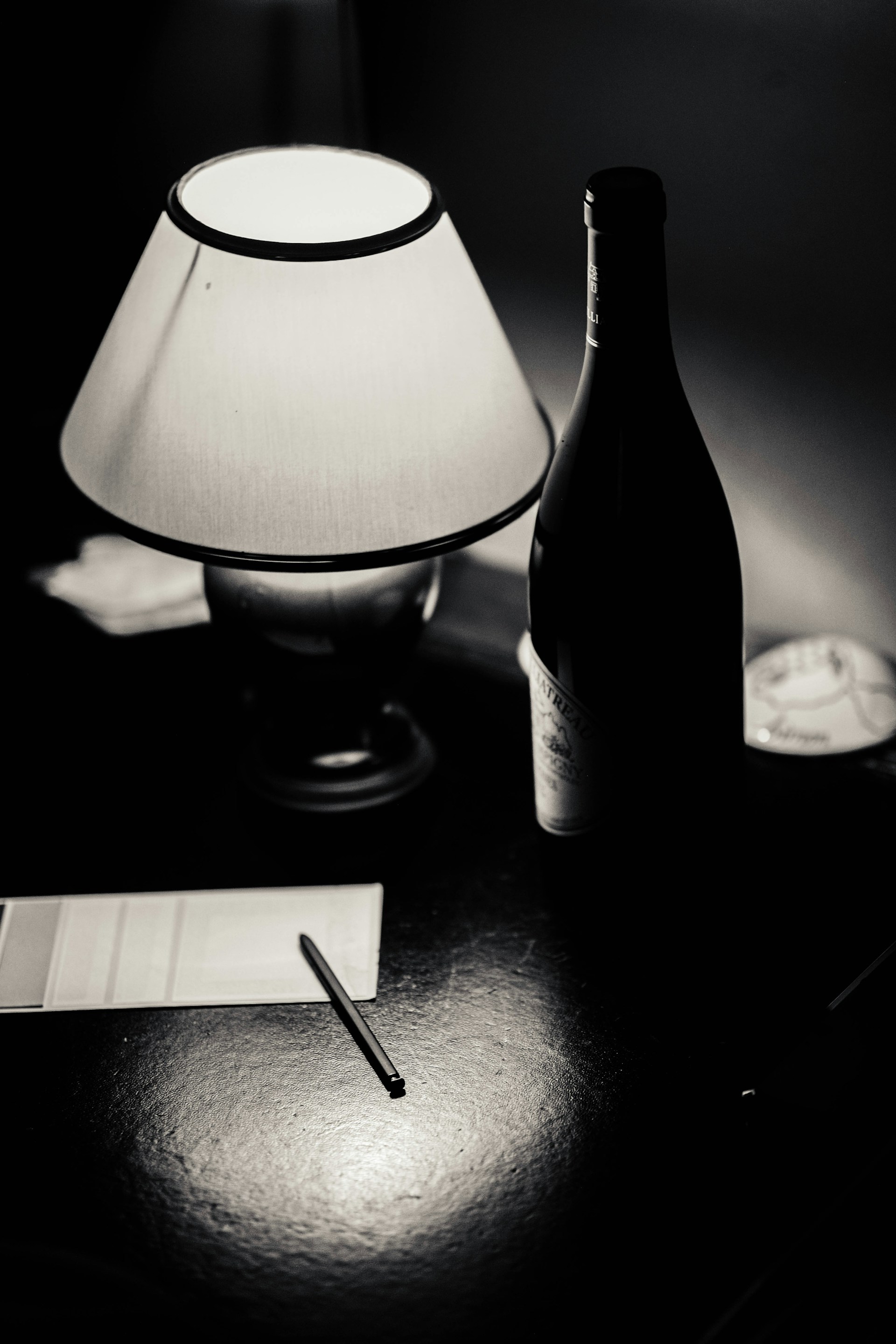 A bottle of wine and a lamp on a table