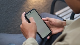 A person sitting on a bench using a cell phone