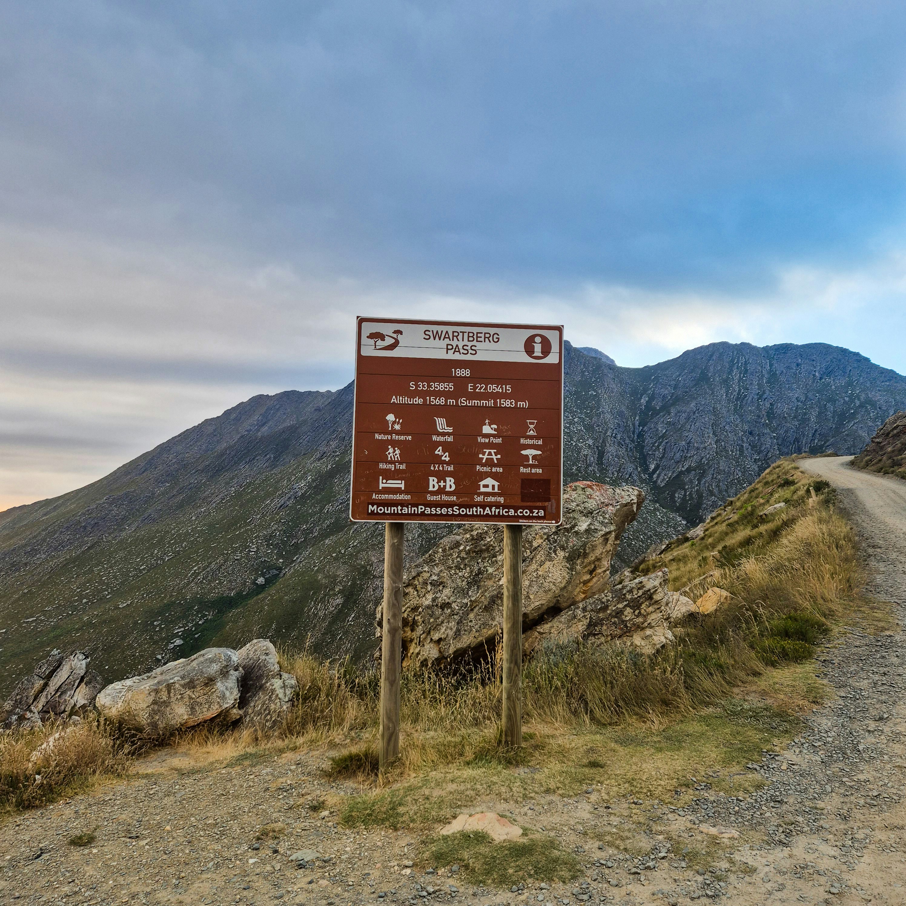 未舗装の道路脇にある看板