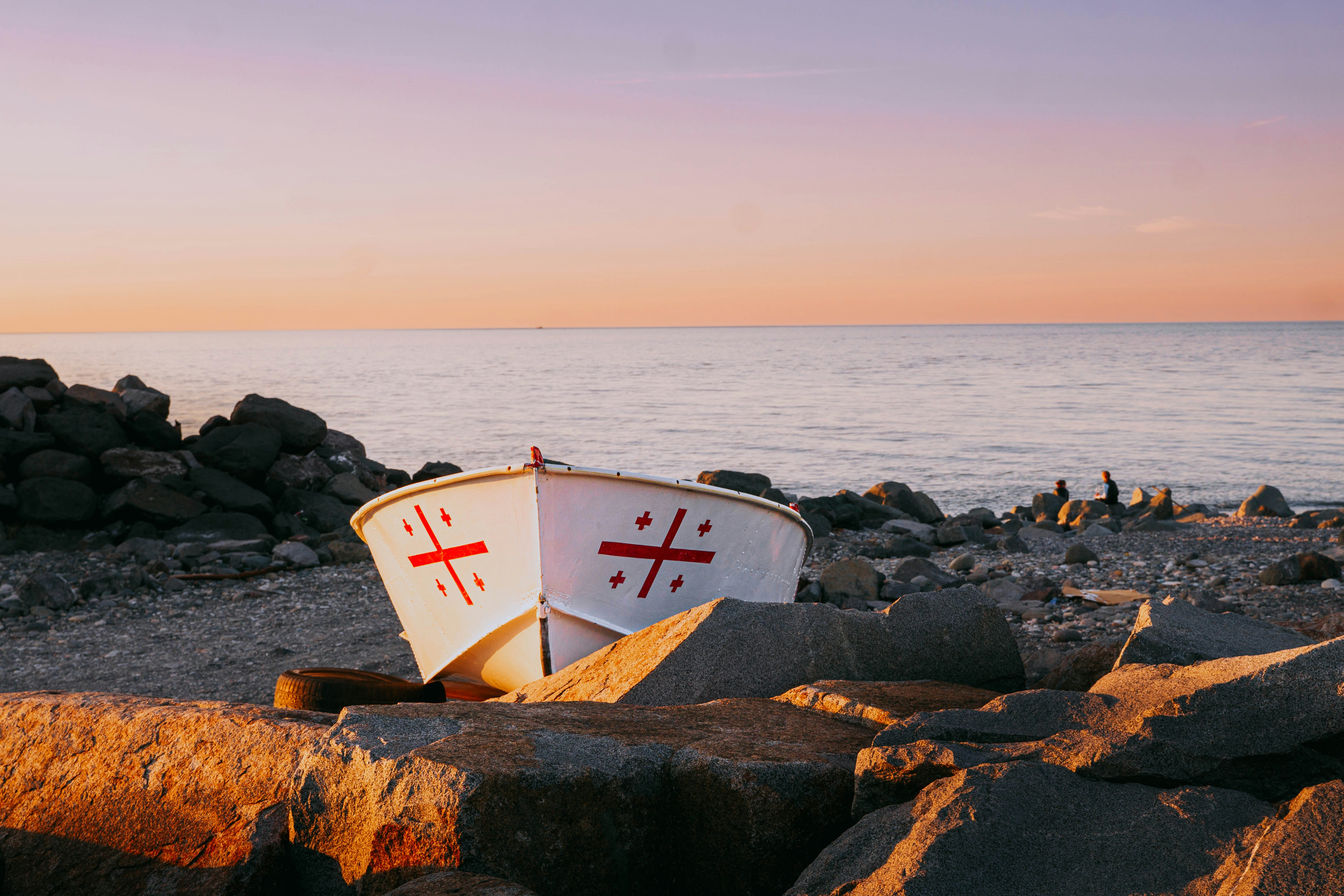 A boat sitting on top of a rocky beach