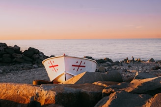 A boat sitting on top of a rocky beach