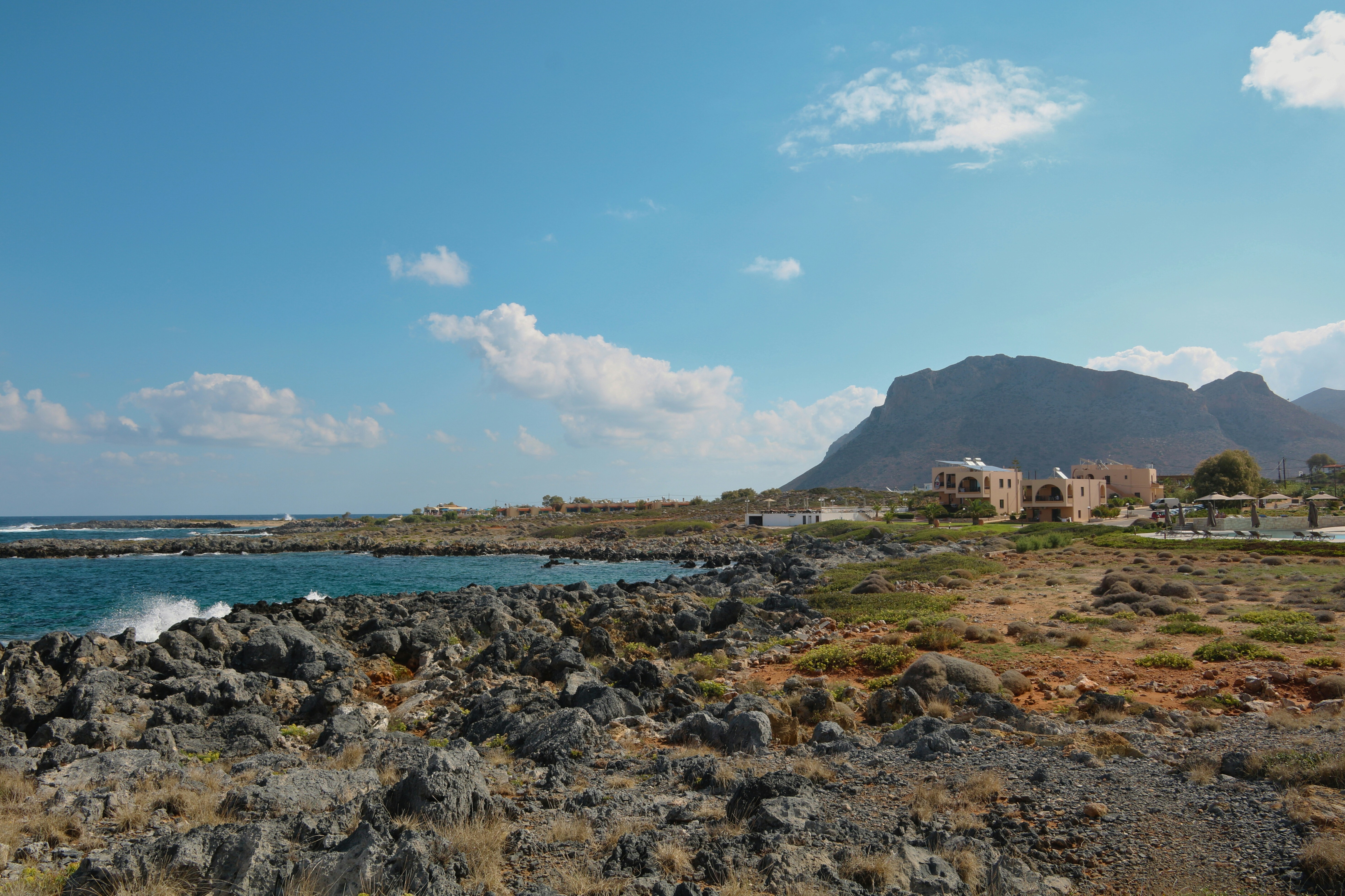 A view of a rocky beach with a mountain in the background, Rock beach
