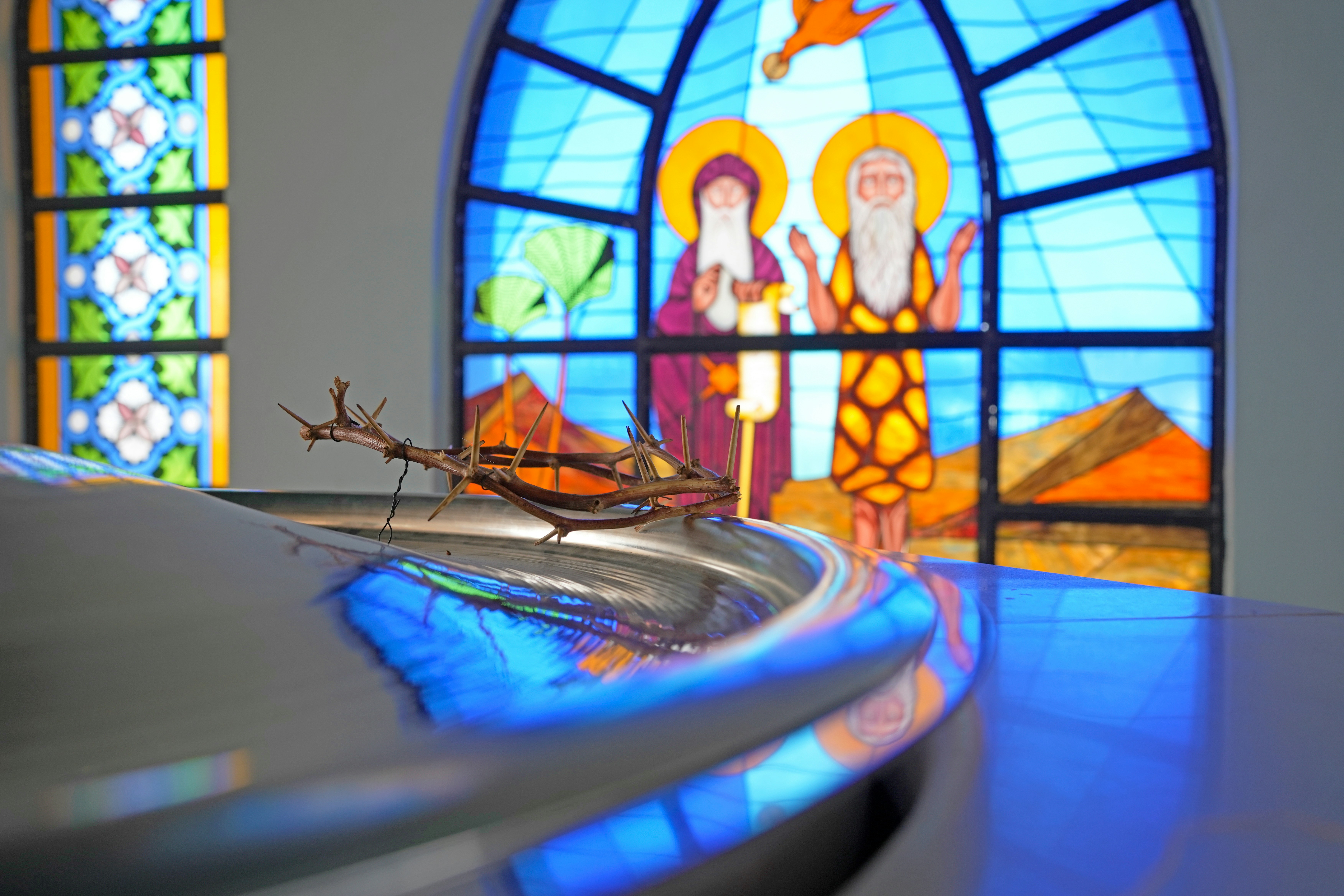A stained glass window with a religious scene in the background