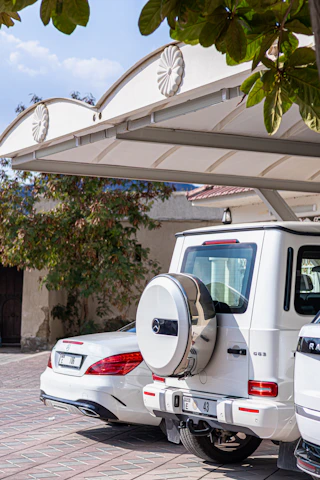 A couple of white cars parked next to each other