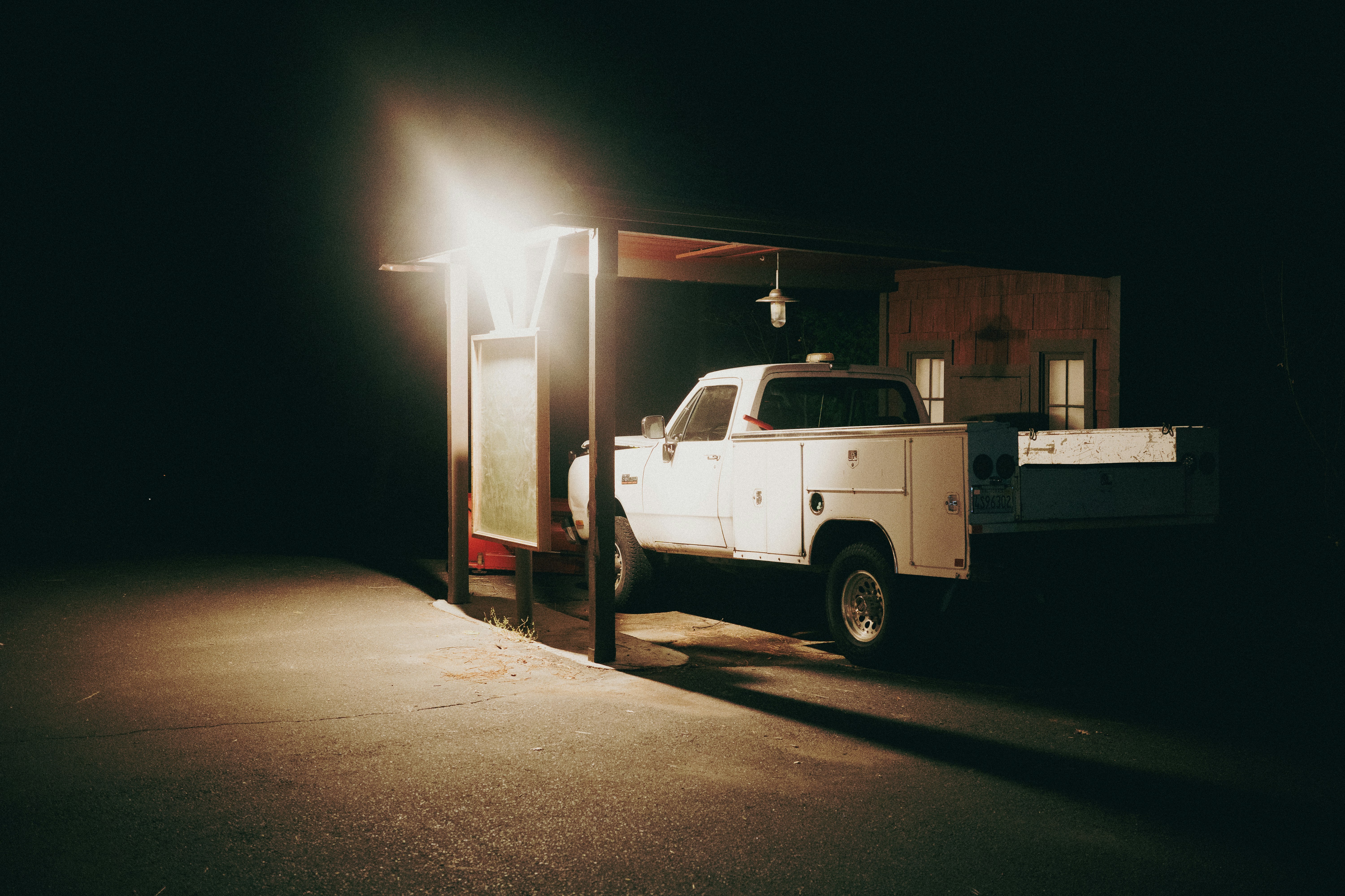 Electric pickup truck plugged into a home charging station in a driveway