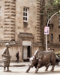 A statue of a man standing next to a bull