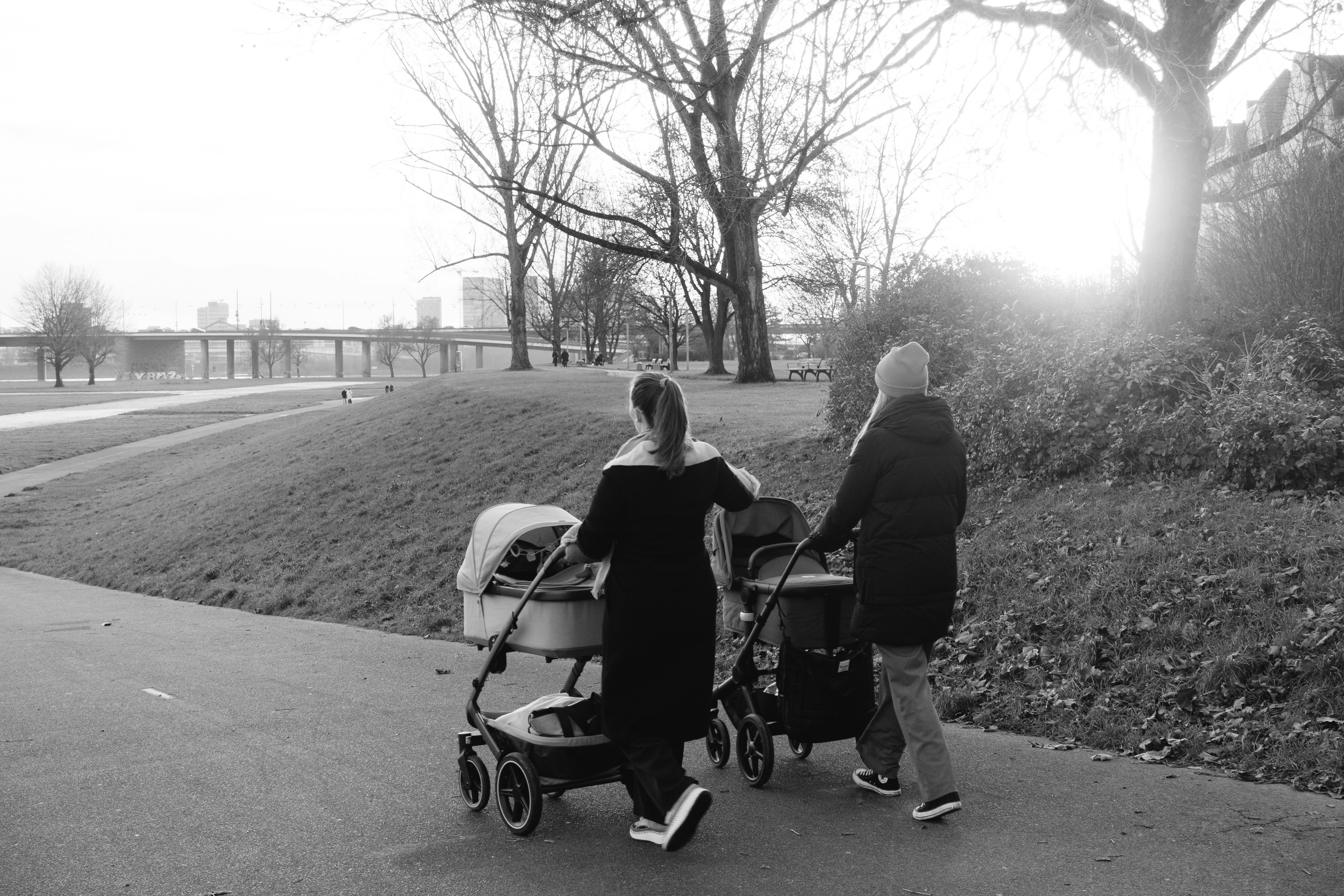 A black and white photo of a woman pushing a stroller