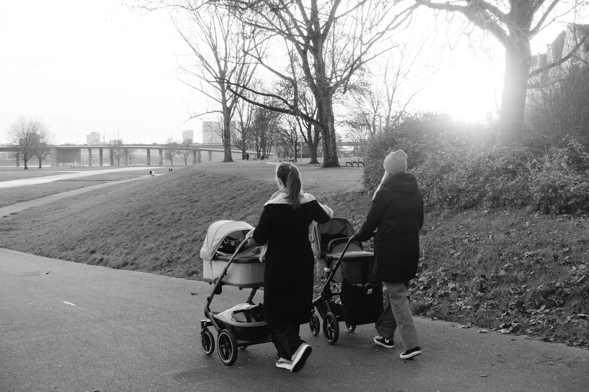 A black and white photo of a woman pushing a stroller