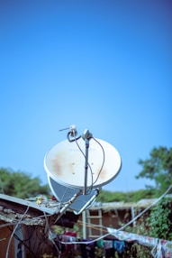 A satellite dish sitting on top of a metal pole