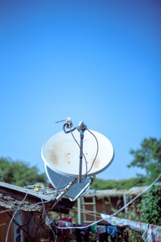 A satellite dish sitting on top of a metal pole