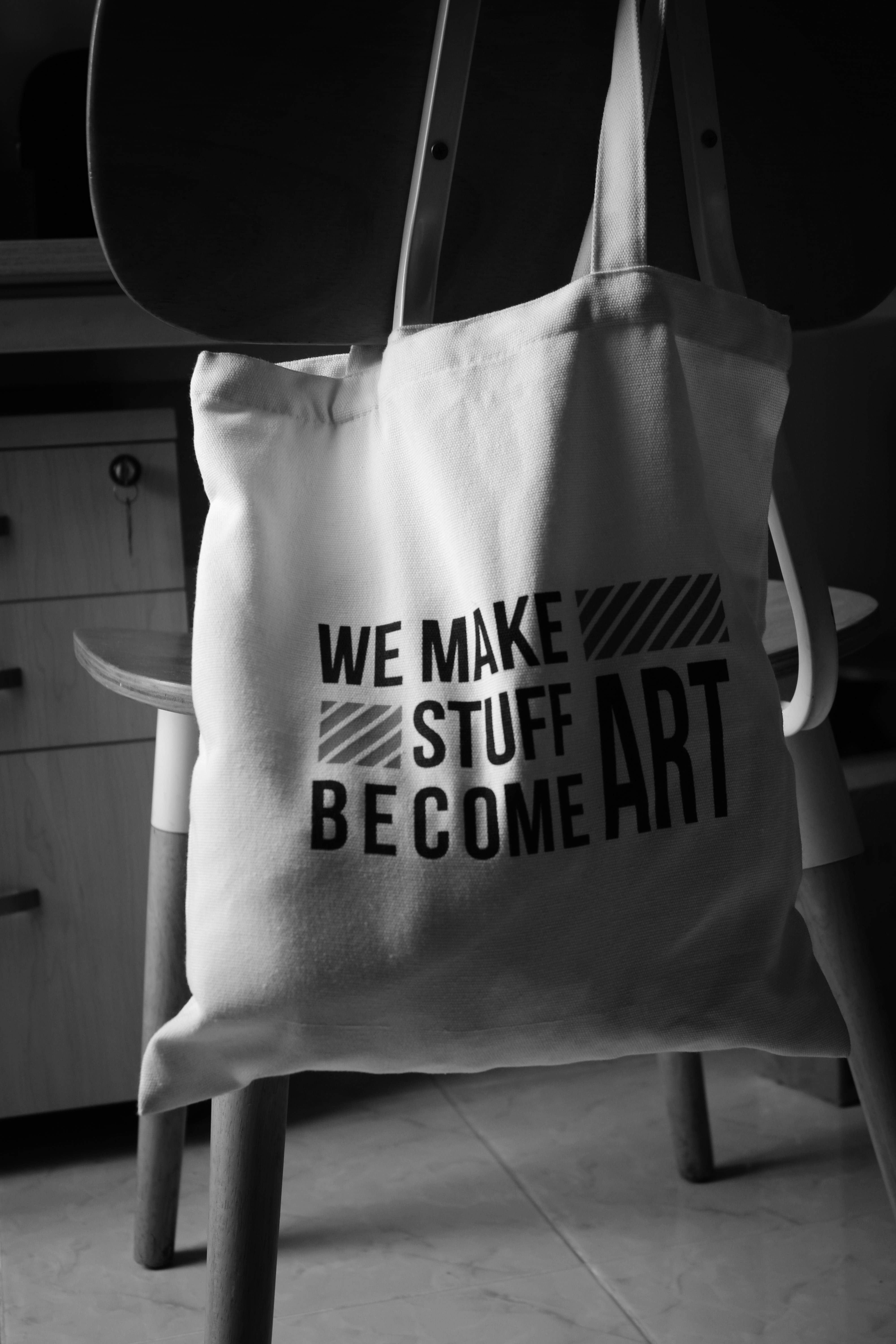 A white tote bag sitting on top of a chair