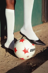 A person standing next to a soccer ball
